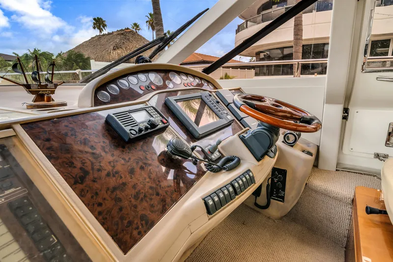 Slide: The Image of Luxurious 2002 Princess 61 yacht helm with wood accents and modern navigation equipment. - 32