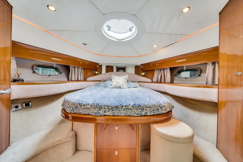 Slide: The Image of Luxurious interior of a 2002 Princess 61 yacht with elegant wood finishes and cozy bedding. - 34