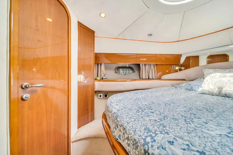 Slide: The Image of Luxurious cabin interior of 2002 Princess 61 yacht with elegant wood finish and cozy bedding. - 36