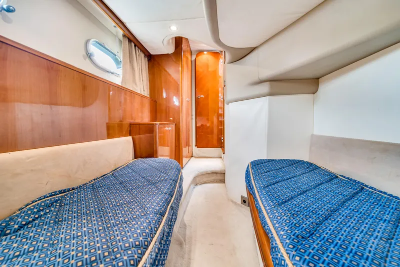 Slide: The Image of Interior cabin of a 2002 Princess 61 yacht with twin beds and wooden paneling. - 49