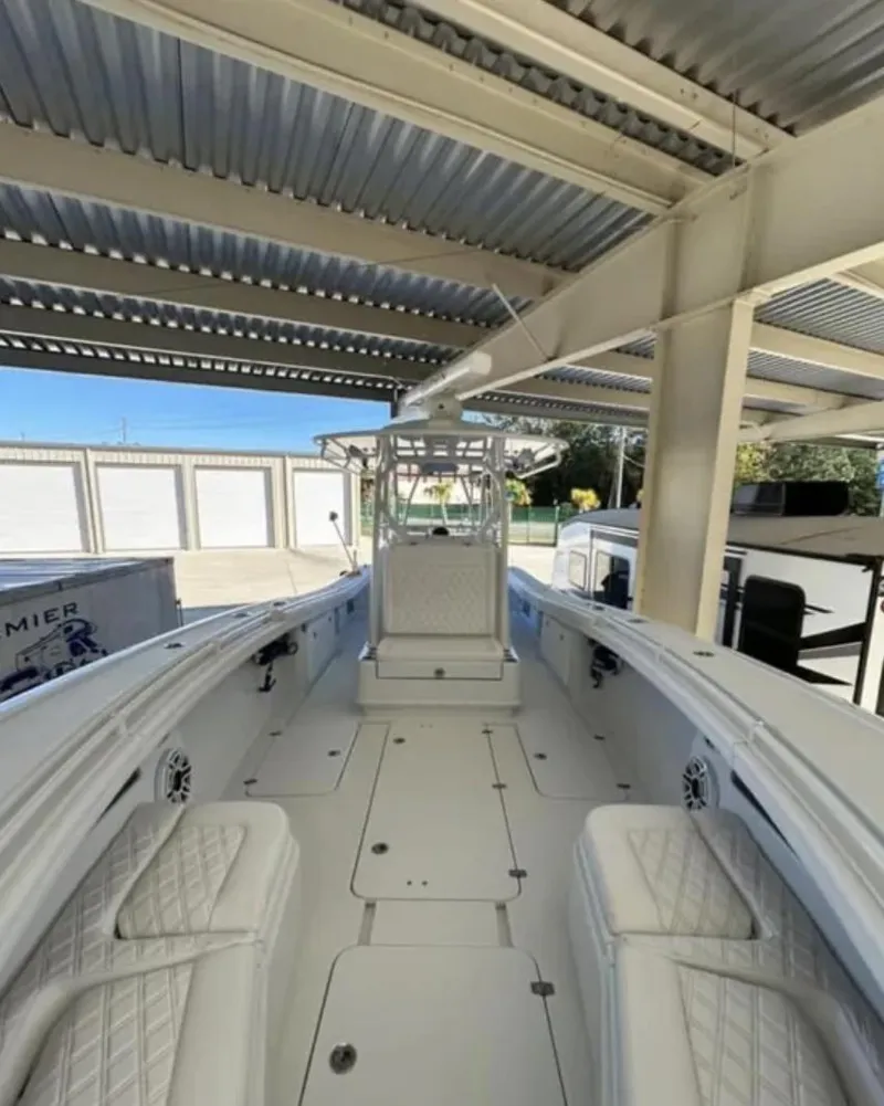 Slide: The Image of 2024 Yellowfin 36 Offshore boat under a metal canopy, showcasing spacious deck and seating. - 7