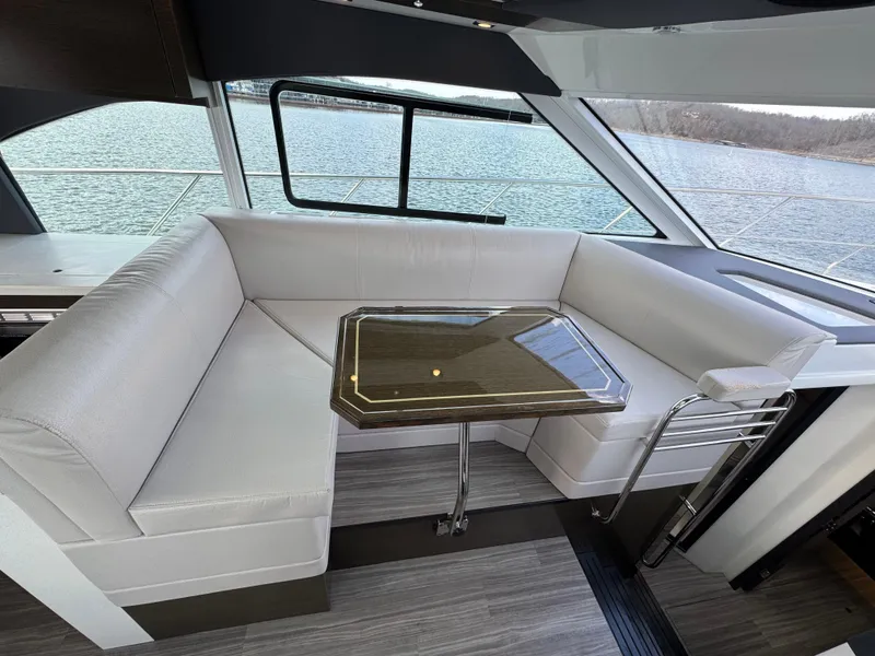 Slide: The Image of 2017 Cruisers Yachts 45 Cantius interior with white seating and table, overlooking water. - 12