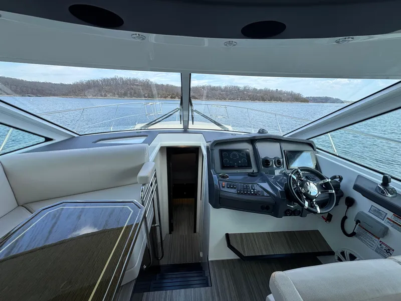 Slide: The Image of Interior view of 2017 Cruisers Yachts 45 Cantius helm with scenic water backdrop. - 14