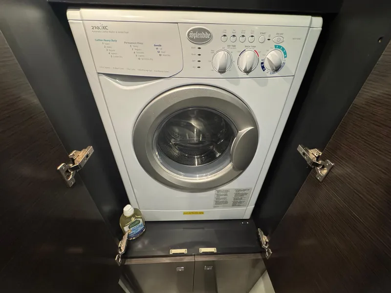 Slide: The Image of Washing machine inside 2017 Cruisers Yachts 45 Cantius, with detergent bottle nearby. - 26