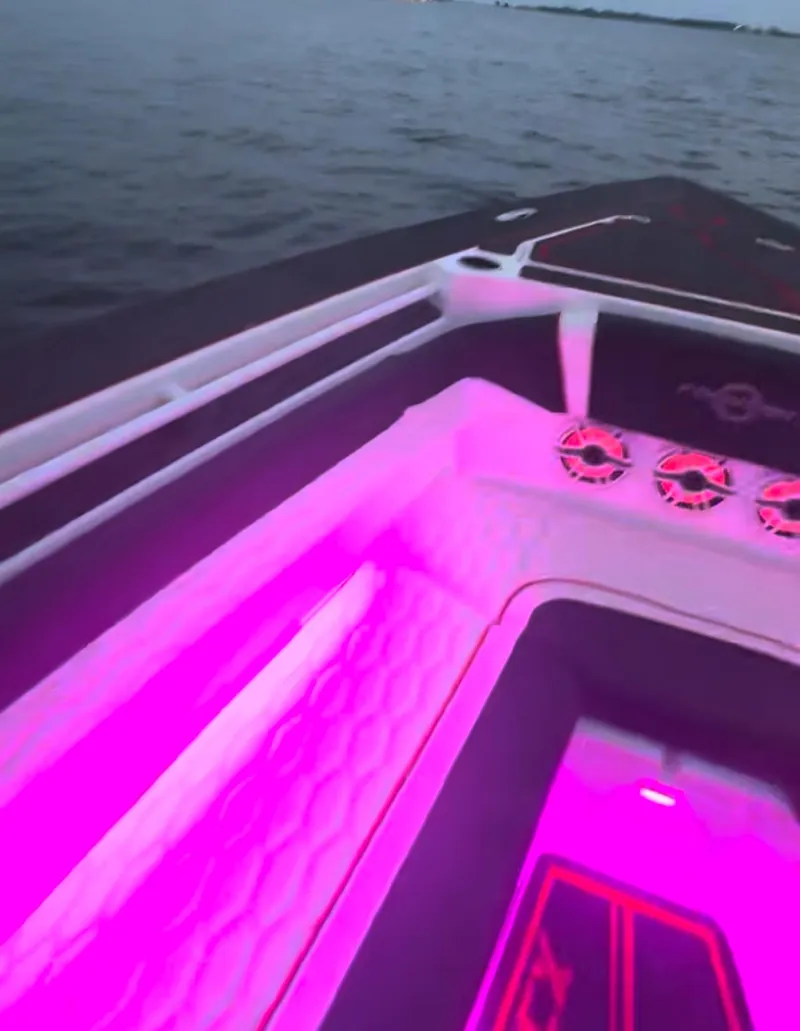 Slide: The Image of 2025 Fountain 38SCX boat interior with vibrant pink LED lighting on the water. - 10