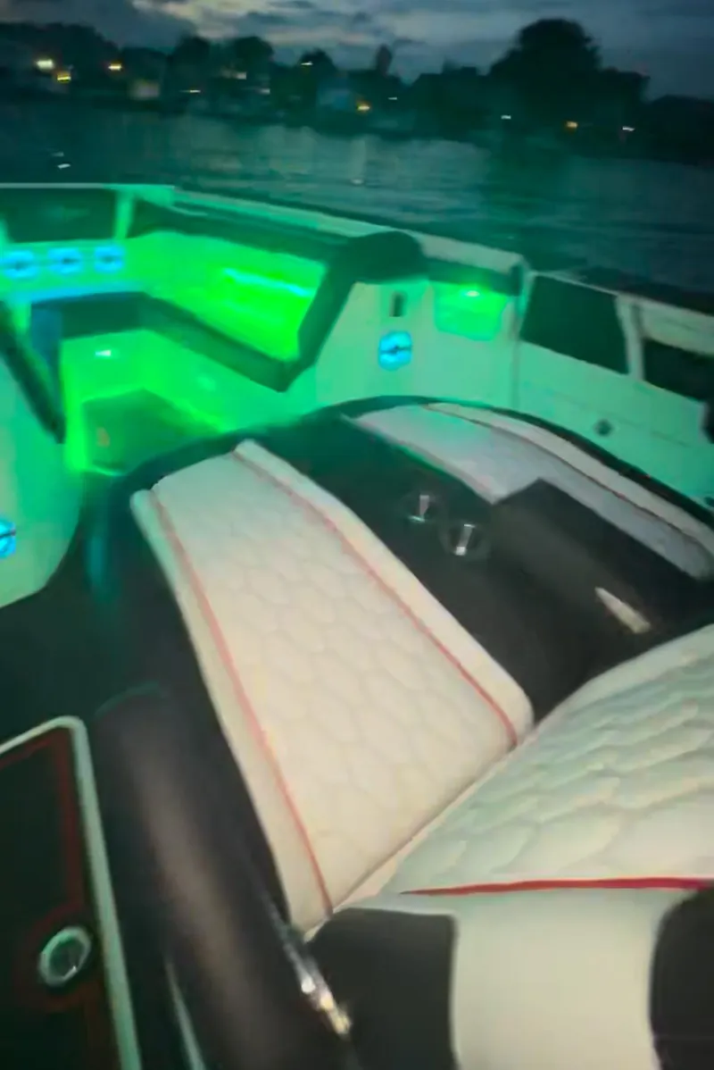 Slide: The Image of 2025 Fountain 38SCX boat interior with illuminated seating and ambient lighting on the water. - 11