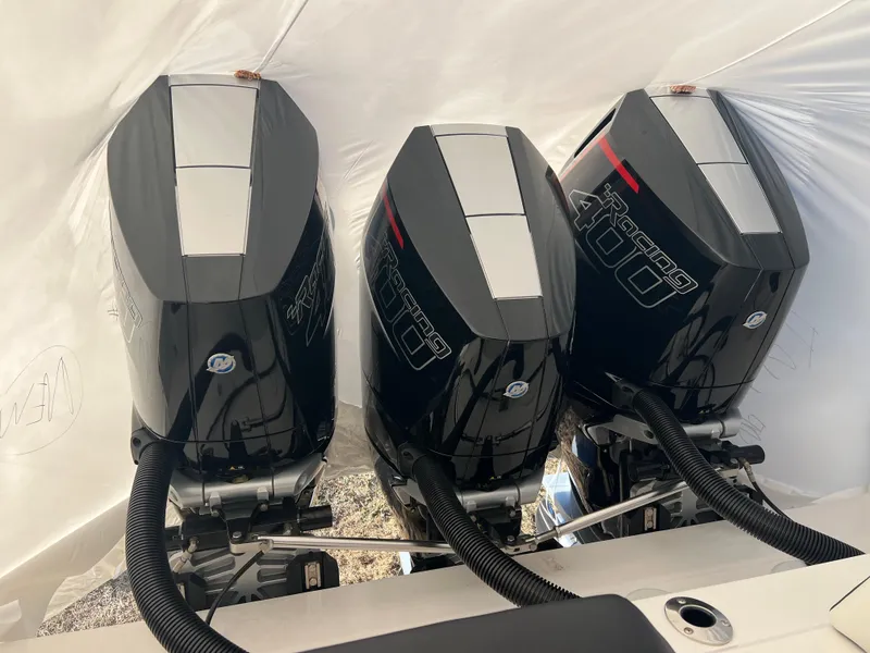 Slide: The Image of Triple outboard engines on a 2025 Fountain 38 SCX boat, covered in protective wrap. - 22
