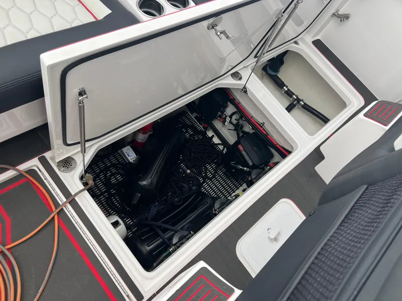 Slide: The Image of 2025 Fountain 38 SCX boat storage compartment with open hatch, showcasing interior equipment and wiring. - 25
