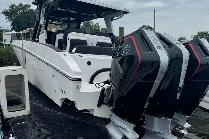 Slide: The Image of 2025 Fountain 38SCX boat with dual outboard engines, docked on a cloudy day. - 4