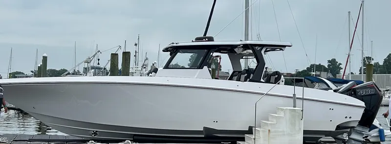 Slide: The Image of 2025 Fountain 38SCX boat docked at marina, sleek design, overcast sky. - 5