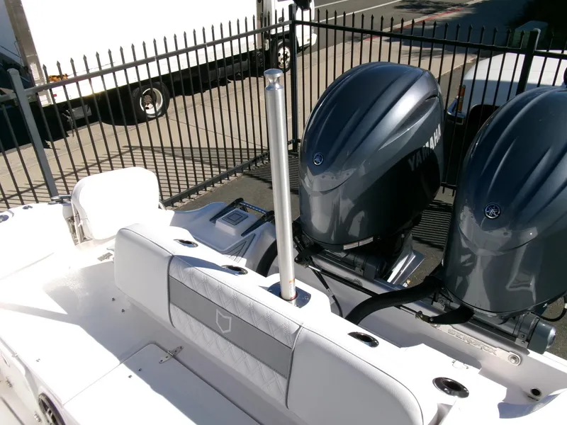 Slide: The Image of 2025 Sea Fox 268 Commander boat with dual Yamaha engines, docked near a fence. - 37