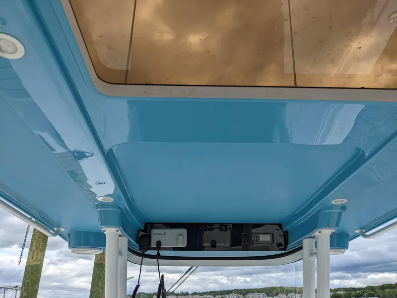 Slide: The Image of Edgewater 320 CC 2018 boat's blue underside with electronics, under cloudy sky. - 11