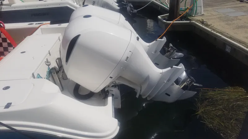 Slide: The Image of 2018 Edgewater 320 CC boat with dual outboard engines docked in marina. - 12