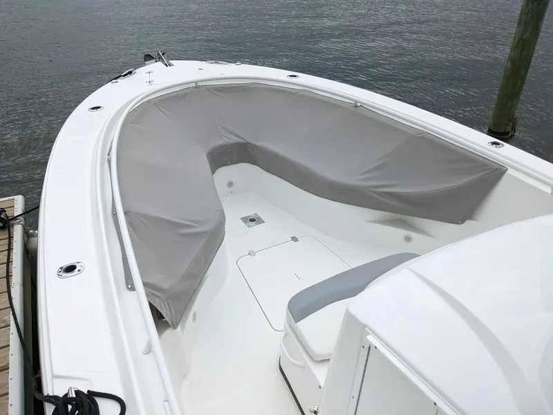 Slide: The Image of 2018 Edgewater 320 CC boat with covered seating area, docked by the water. - 14