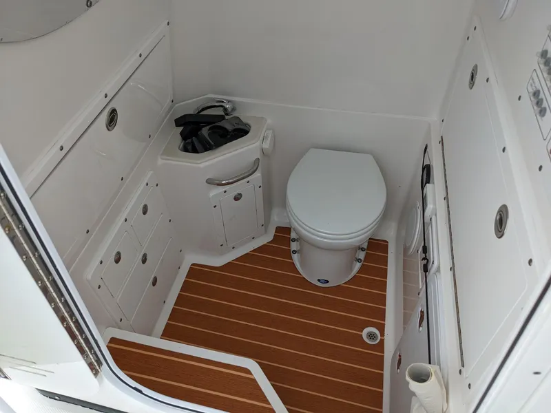 Slide: The Image of 2018 Edgewater 320 CC boat interior with toilet and storage compartments. - 15