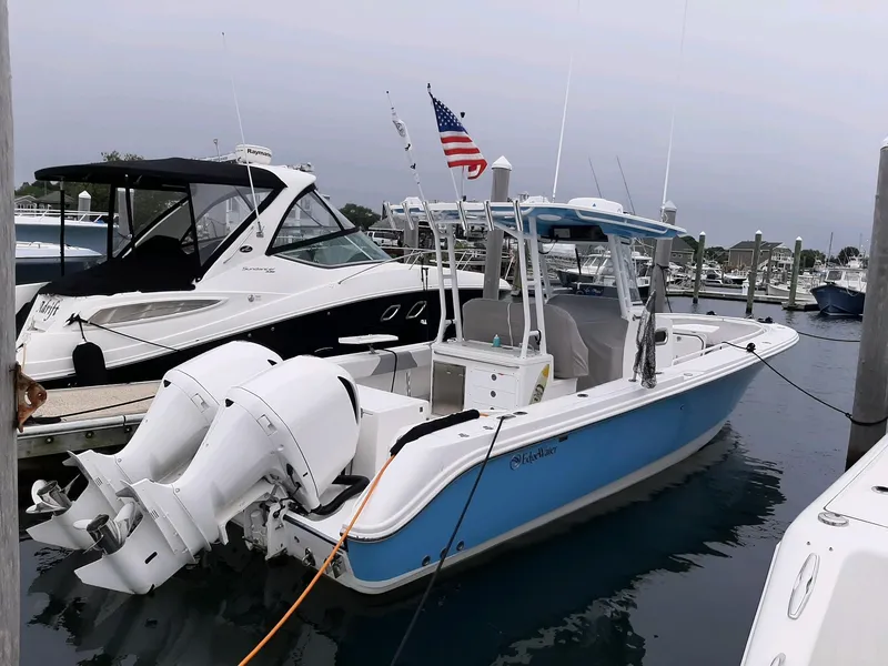 Slide: The Image of 2018 Edgewater 320 CC boat docked with twin engines and American flag. - 2
