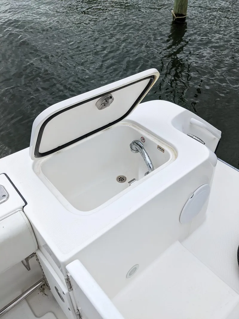 Slide: The Image of 2018 Edgewater 320 CC boat with open storage compartment by the water. - 20