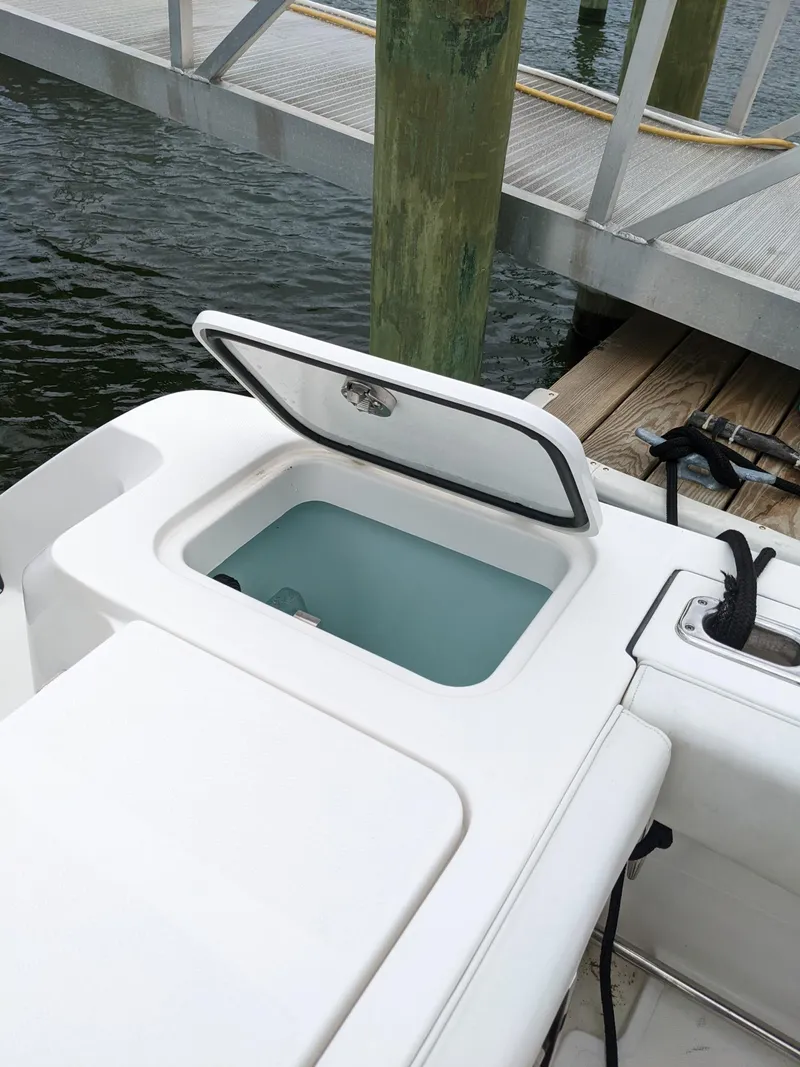 Slide: The Image of 2018 Edgewater 320 CC boat with open storage compartment by a dock. - 21