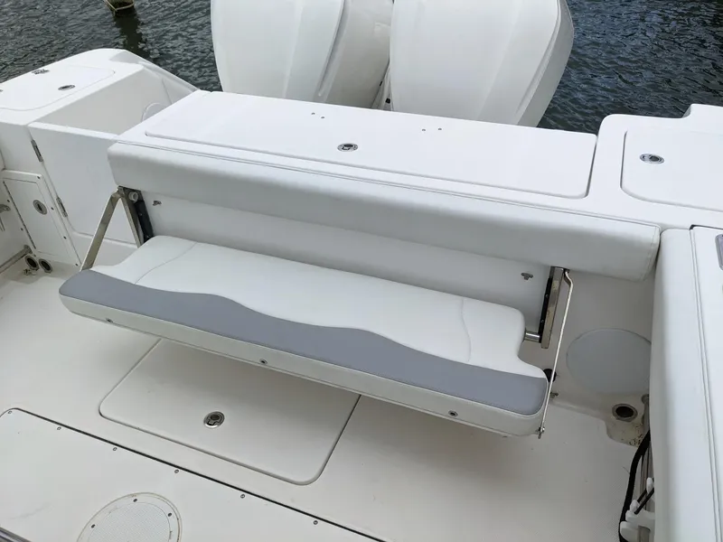 Slide: The Image of 2018 Edgewater 320 CC boat with foldable rear bench seat, white and gray upholstery. - 22