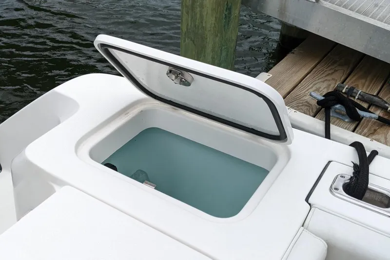 Slide: The Image of Open storage compartment on 2018 Edgewater 320 CC boat docked by water. - 26