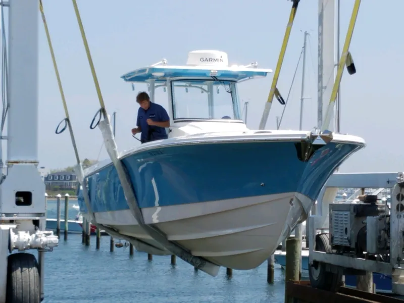 Slide: The Image of 2018 Edgewater 320 CC boat being lifted at a marina. - 5