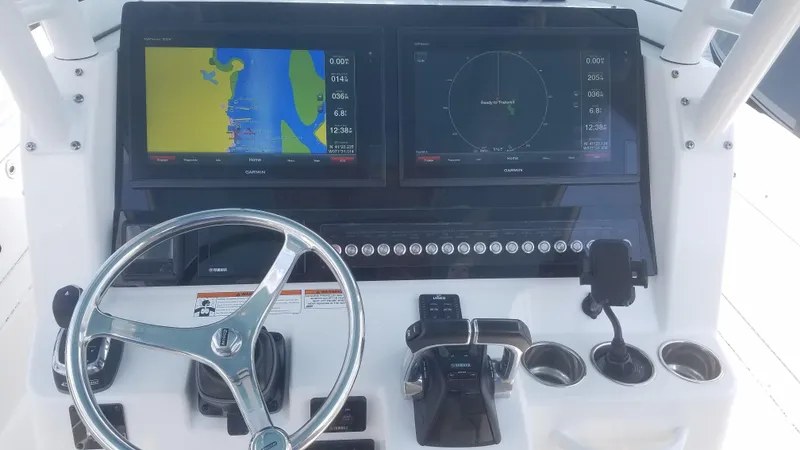 Slide: The Image of Edgewater 320 CC 2018 helm with Garmin navigation displays and steering wheel. - 6