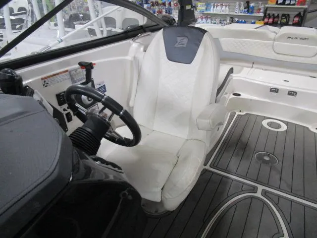 Slide: The Image of 2017 Larson 292 LXI boat interior with steering wheel and seating area. - 17
