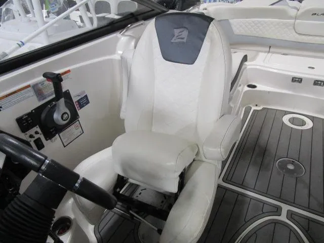 Slide: The Image of 2017 Larson 292 LXI boat interior with white captain's chair and steering wheel. - 19