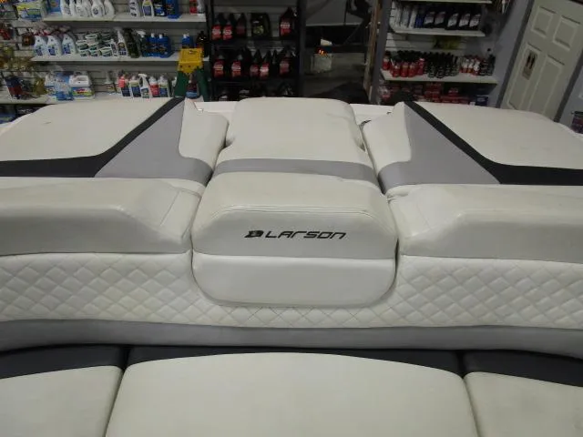 Slide: The Image of 2017 Larson 292 LXI boat interior with white quilted seating in a store setting. - 21