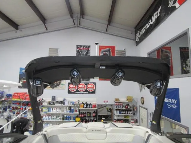 Slide: The Image of 2017 Larson 292 LXI boat interior with speakers and accessories in a showroom. - 22