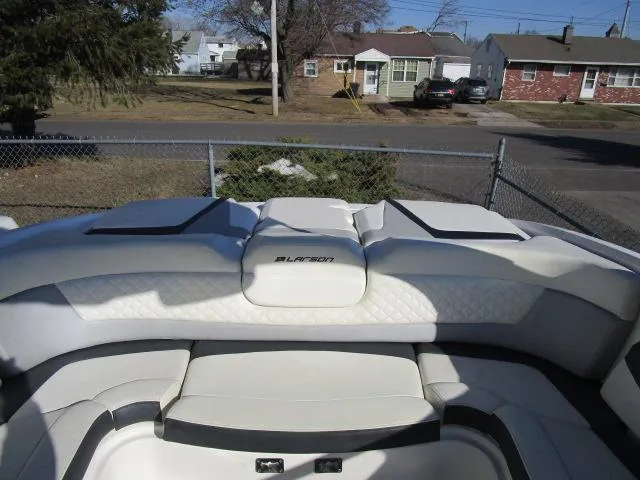 Slide: The Image of 2017 Larson 292 LXI boat interior with white seating in a residential area. - 29
