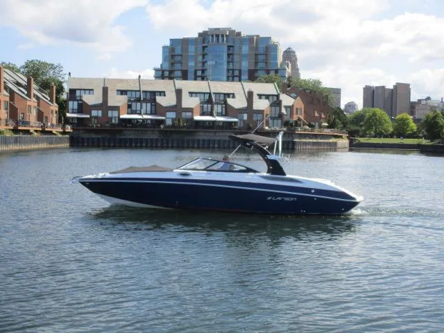 Slide: The Image of 2017 Larson 292 LXI boat cruising on a calm urban waterway. - 3