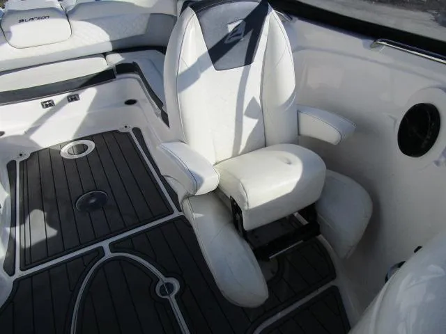 Slide: The Image of 2017 Larson 292 LXI boat interior with white seating and dark flooring. - 33