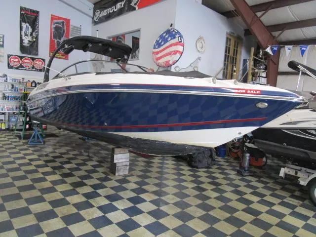 Slide: The Image of 2017 Larson 292 LXI boat displayed indoors on checkered floor. - 4