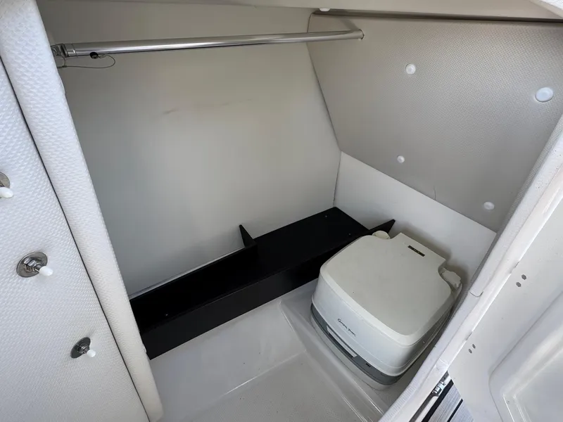 Slide: The Image of 2023 Yamaha Boats 252SD interior storage space with portable toilet. - 14