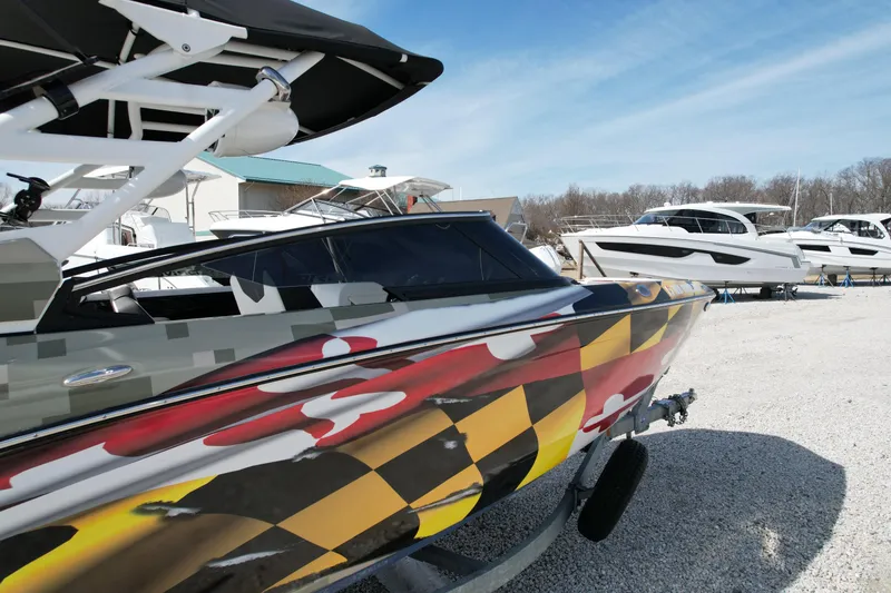 Slide: The Image of 2023 Yamaha Boats 252SD with vibrant custom paint, displayed outdoors on a sunny day. - 4