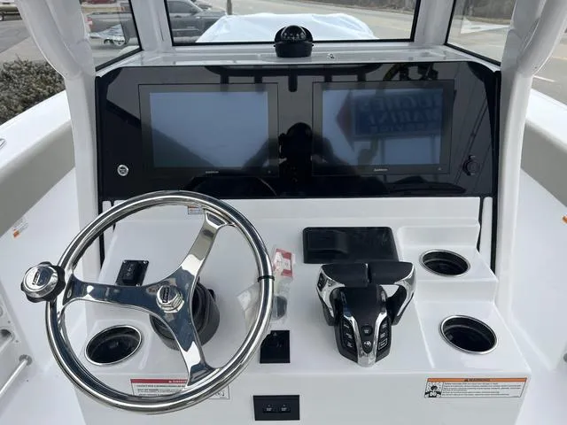 Slide: The Image of 2025 Sportsman Heritage 261 boat dashboard with dual screens and steering wheel. - 10