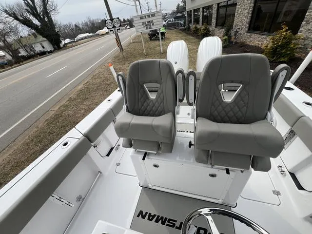 Slide: The Image of 2025 Sportsman Heritage 261 boat interior with dual gray seats, parked roadside. - 14