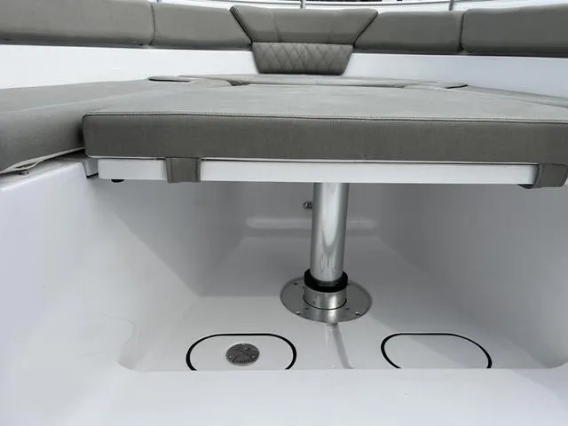 Slide: The Image of 2025 Sportsman Heritage 261 boat seating area with gray cushions and storage compartments. - 18