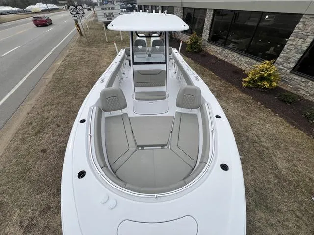 Slide: The Image of 2025 Sportsman Heritage 261 boat, sleek design, parked roadside near building. - 20