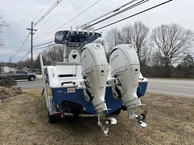 Slide: The Image of 2025 Sportsman Heritage 261 boat with dual Yamaha 200 engines, parked on grass. - 22