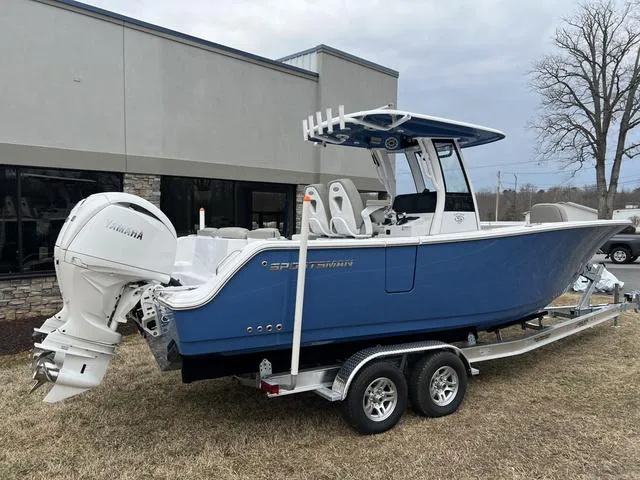 Slide: The Image of 2025 Sportsman Heritage 261 boat on trailer, blue hull, Yamaha outboard, parked outdoors. - 27