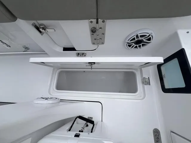 Slide: The Image of 2025 Sportsman Heritage 261 boat interior with open storage compartment and speaker. - 8