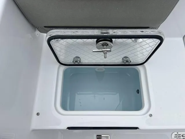 Slide: The Image of Livewell compartment on 2025 Sportsman Heritage 261 boat, open lid, white interior. - 9