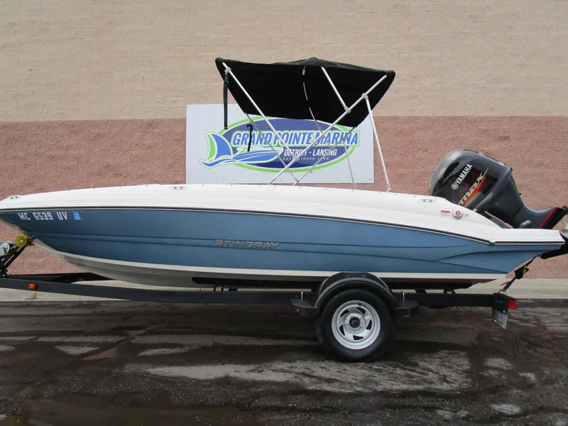 Slide: The Image of 2022 Stingray 182 boat with canopy on trailer, displayed at Grand Pointe Marina. - 1