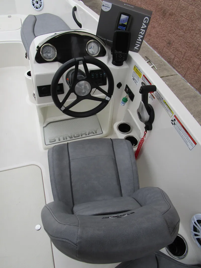 Slide: The Image of 2022 Stingray 182 boat cockpit with steering wheel, Garmin navigation, and gray seating. - 10