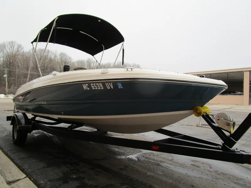 Slide: The Image of 2022 Stingray 182 boat on trailer with canopy, parked outdoors. - 5