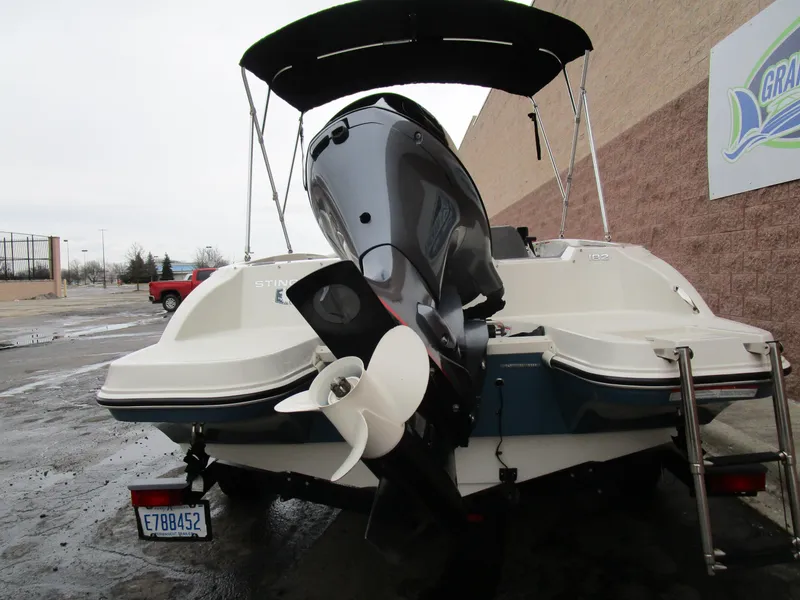 Slide: The Image of 2022 Stingray 182 boat, rear view with outboard motor, parked outdoors. - 7