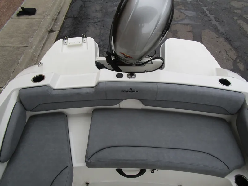 Slide: The Image of 2022 Stingray 182 boat interior with gray seating and outboard motor. - 8