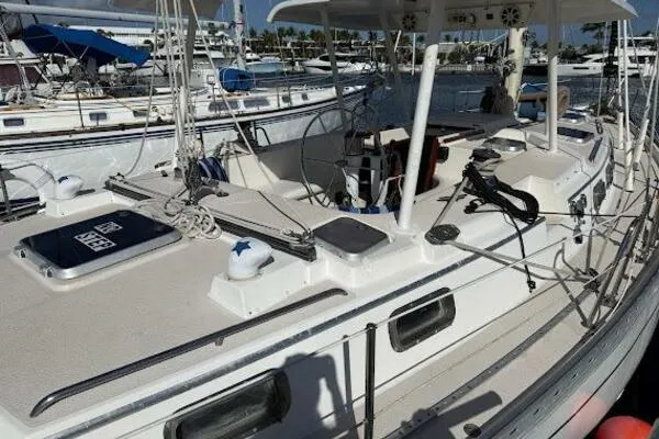 Slide: The Image of 1989 Catalina Morgan 440 sailboat docked in marina, showcasing deck and rigging. - 1